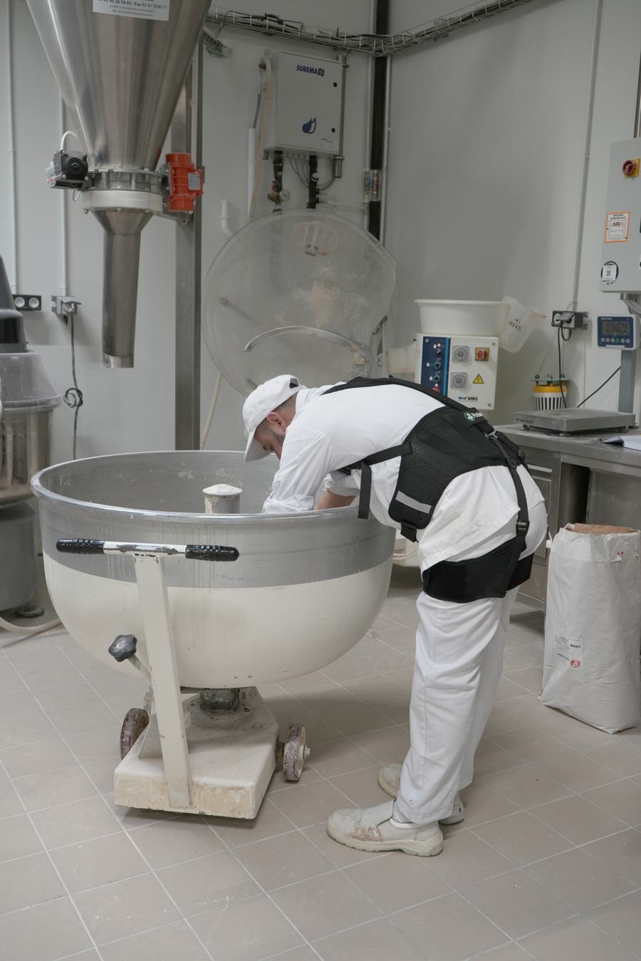 Professionnel penché au-dessus d’un pétrin dans un atelier